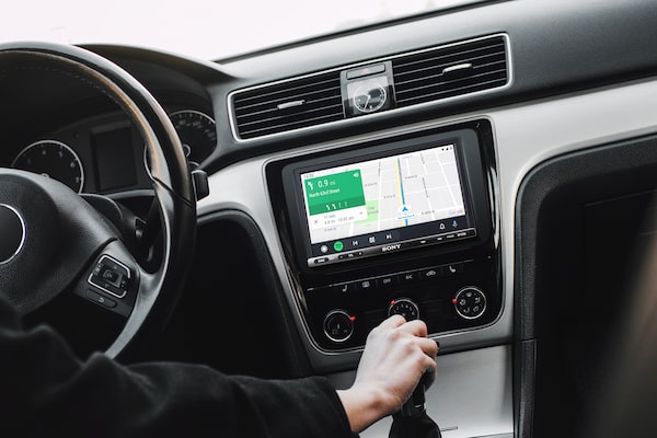Imagen del receptor de medios digitales de 17,6 cm (6,95") con WebLink Cast en un auto con conductor que usa Android Auto.